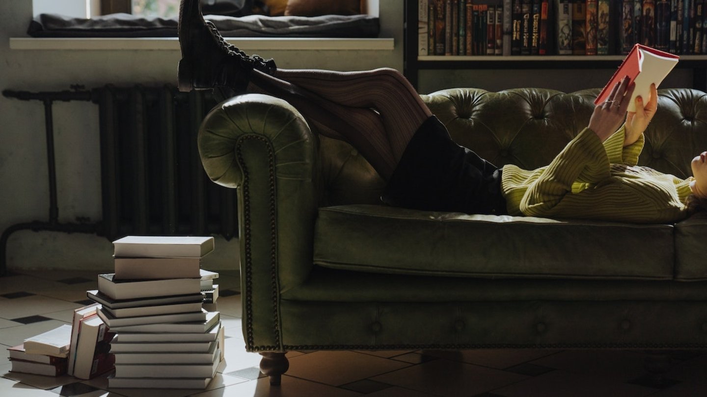 Una mujer tumbada leyendo